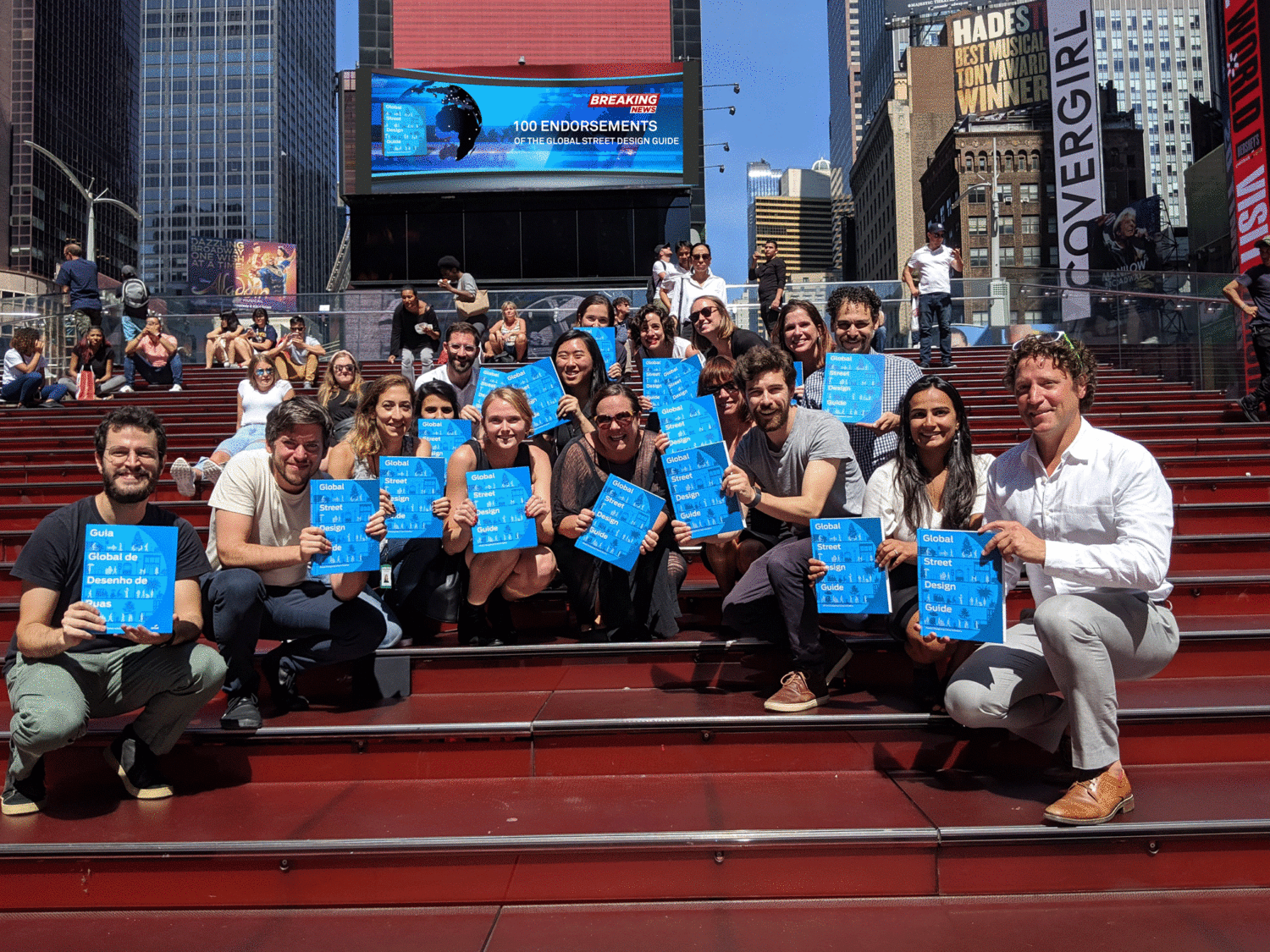 GDCI staff holding copies of the GSDG with a 100 endorsement breaking news sign in the background